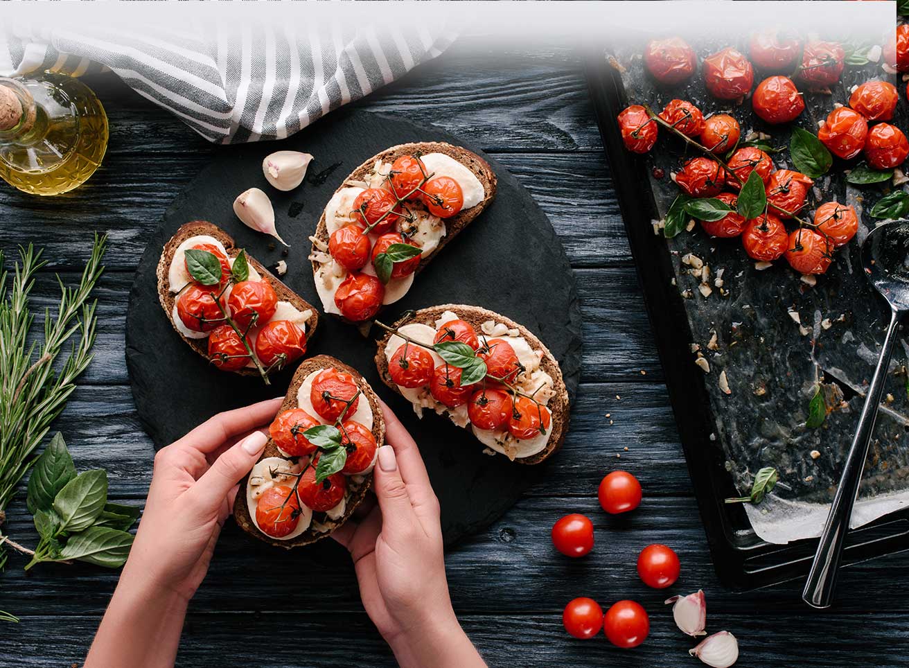  sandwiches with cheese and baked tomatoes on dark wooden table