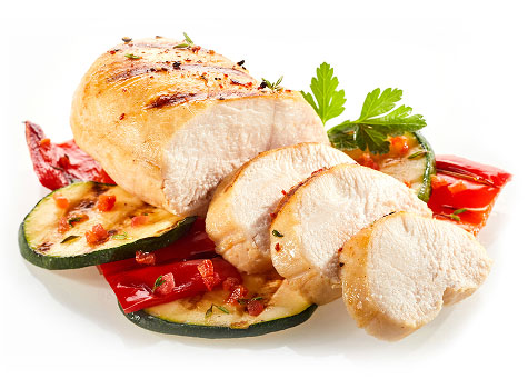 Sliced chicken breast with roasted peppers and zucchini, garnished with parsley.