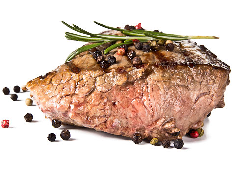 Piece of steak garnished with peppercorns and rosemary.
